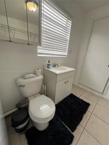 a bathroom with a toilet a sink and a window