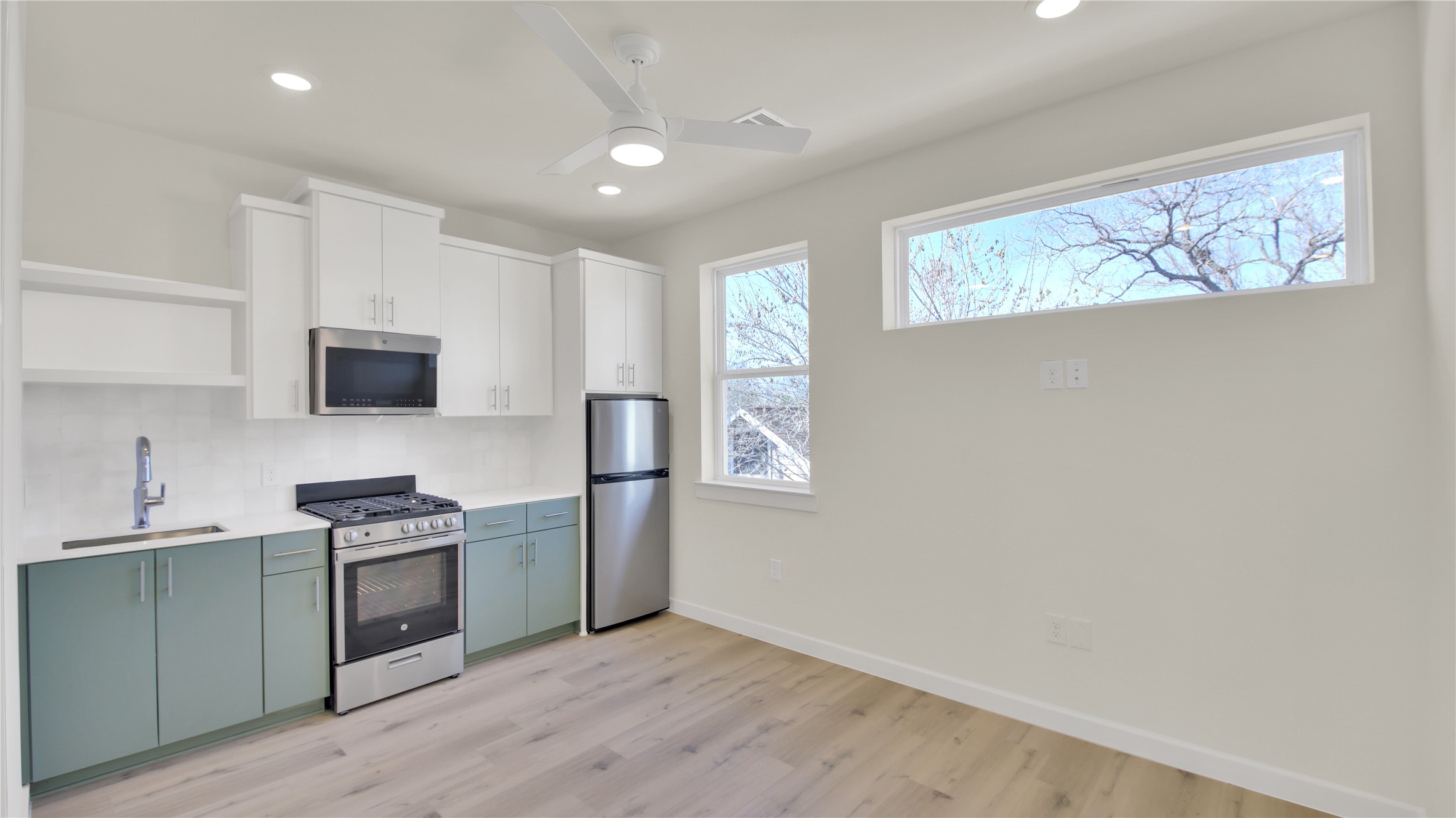 6802 Montana Street, Unit 2 Austin, TX 78741 - Photo 5 of 11 Kitchen featuring dual tone cabinets, open shelves, stainless steel appliances, a ceiling fan, and light wood-style floors