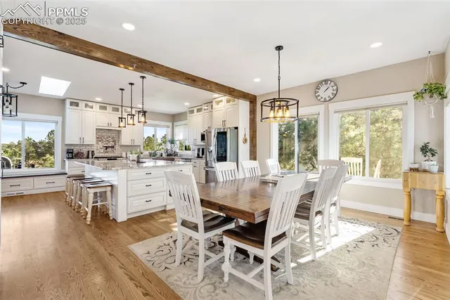a view of a dining room and livingroom with furniture wooden floor a chandelier