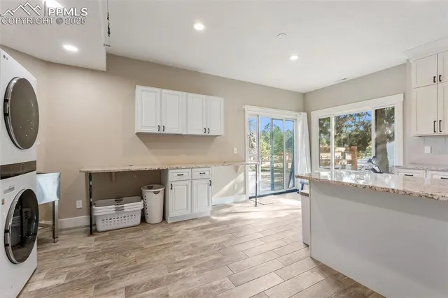 a large white kitchen with a large window a sink and a stove