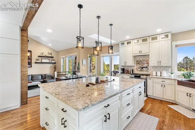 a kitchen with stainless steel appliances granite countertop a sink and a stove