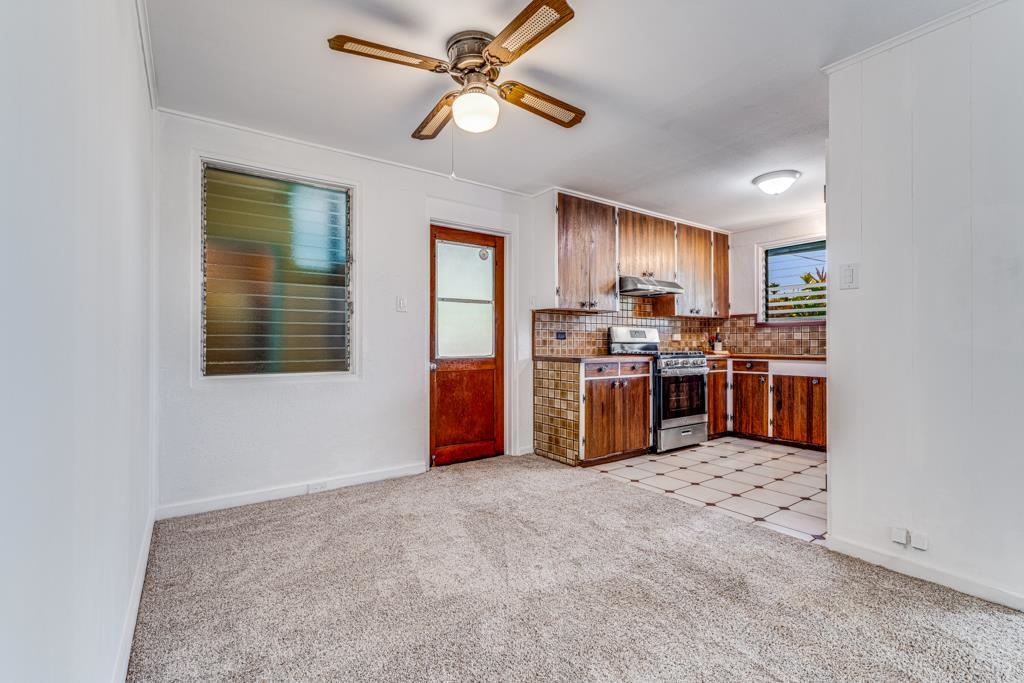720 Mopua Street Haiku, HI 96708 - Photo 7 of 22 a kitchen with stainless steel appliances granite countertop a stove top oven a refrigerator a sink and a window