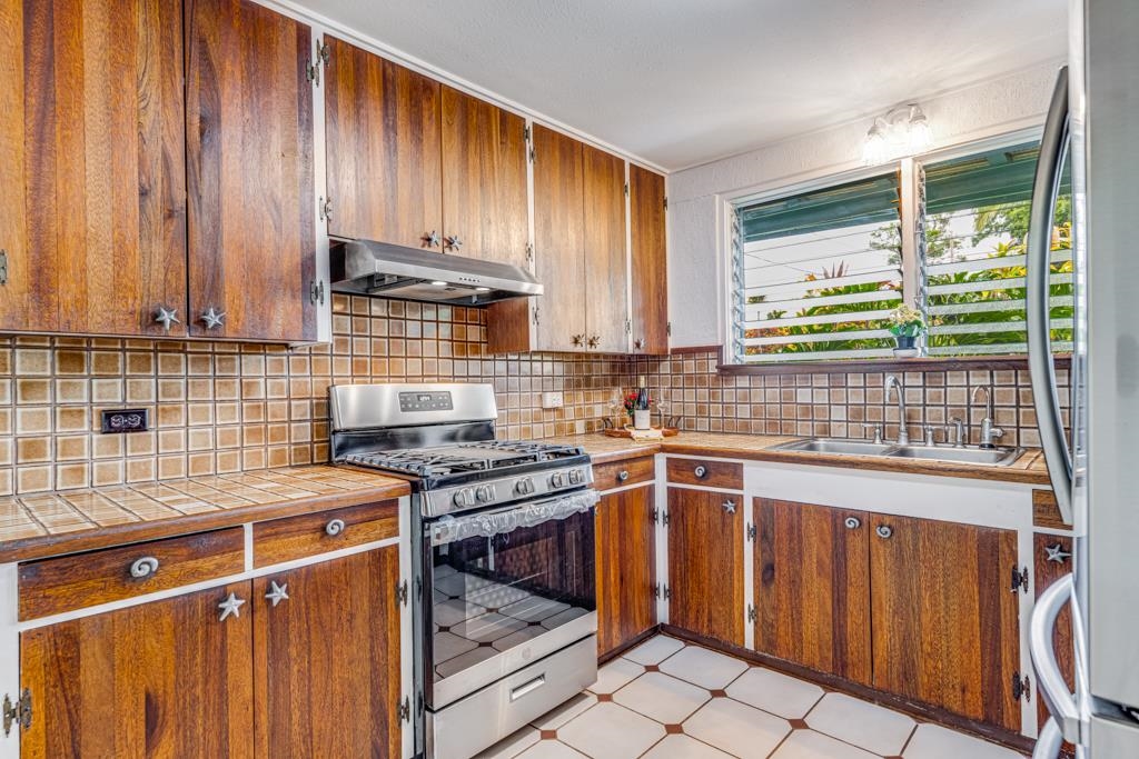 720 Mopua Street Haiku, HI 96708 - Photo 8 of 22 a kitchen with stainless steel appliances a stove a sink and a microwave