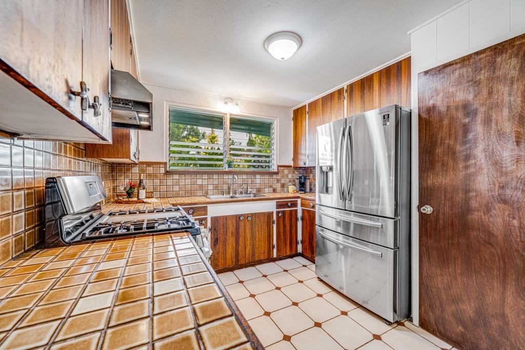 720 Mopua Street Haiku, HI 96708 - Photo 9 of 22 a kitchen with stainless steel appliances granite countertop a refrigerator and a stove top oven