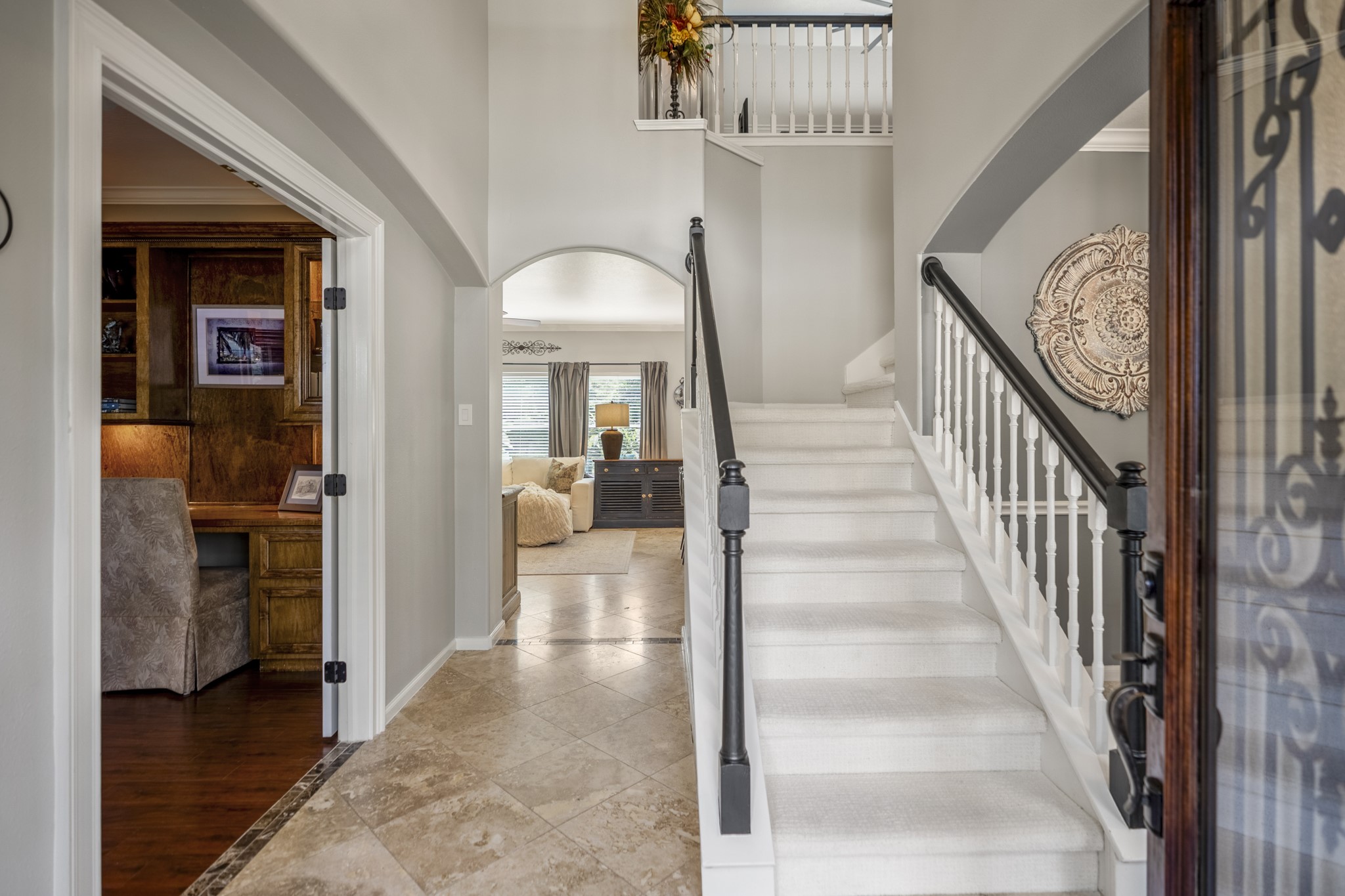 20235 Eden Pines Spring, TX 77379 - Photo 4 of 50 Step inside and the layout starts to open up right away, with travertine flooring carrying you through the entry. French doors to the office are on the left, while the staircase rises along the right with the formal dining room tucked just beyond it. Straight ahead, the main living area begins to come into view toward the back of the home.