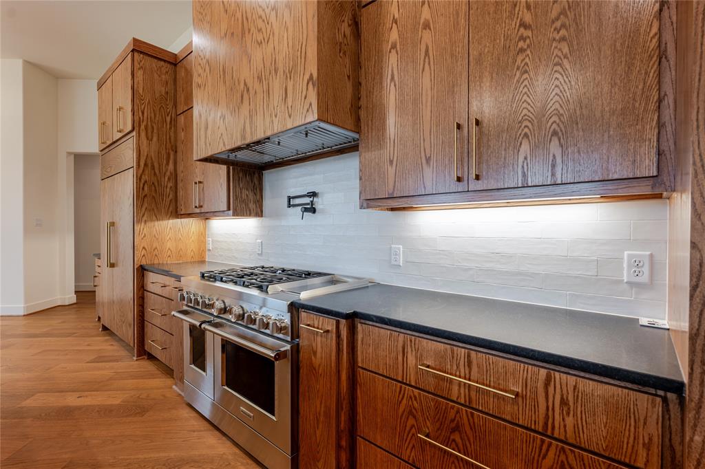 2005 Denali Pass Aledo, TX 76008 - Photo 13 of 36 a kitchen with granite countertop a stove and a wooden cabinets