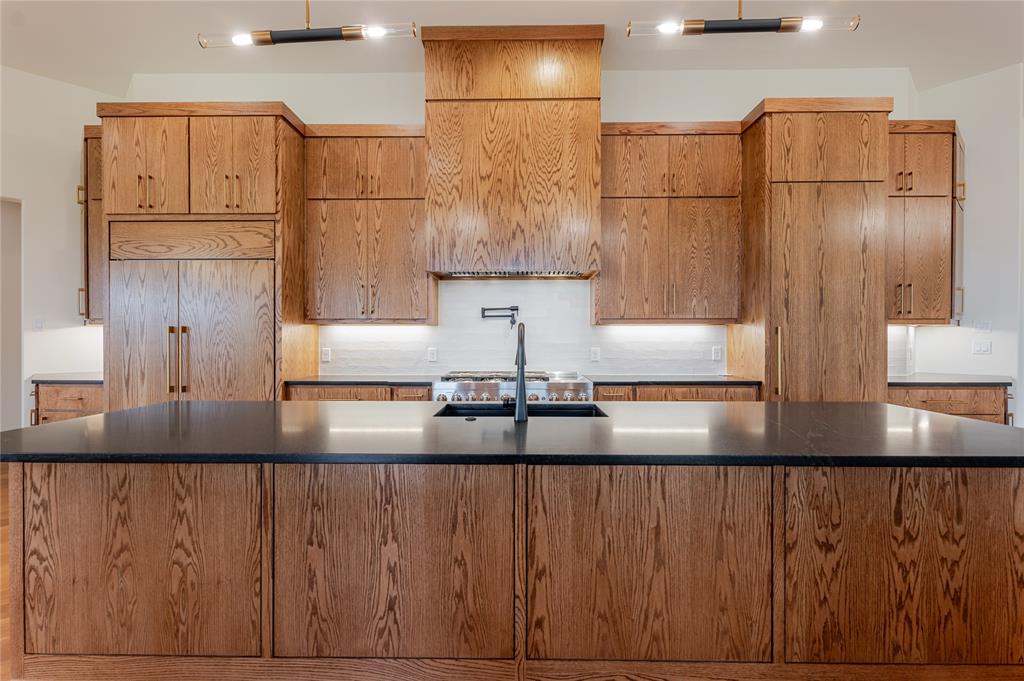 2005 Denali Pass Aledo, TX 76008 - Photo 14 of 36 a kitchen with kitchen island granite countertop a refrigerator a sink and white cabinets