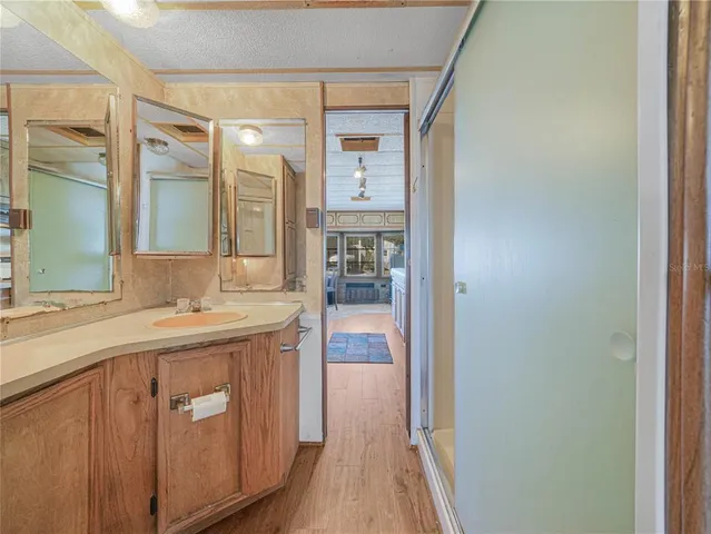 a large bedroom with a bed and wooden floor
