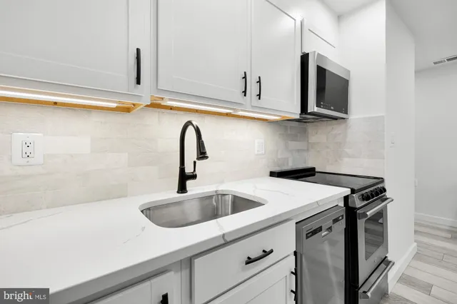 a kitchen with stainless steel appliances granite countertop a sink and a microwave