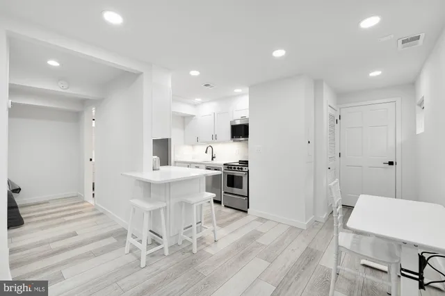 a large white kitchen with a table and chairs in it