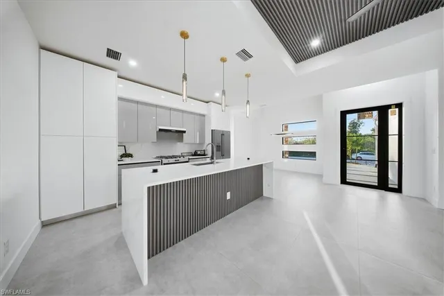 a kitchen with stainless steel appliances kitchen island granite countertop a refrigerator a sink and a oven