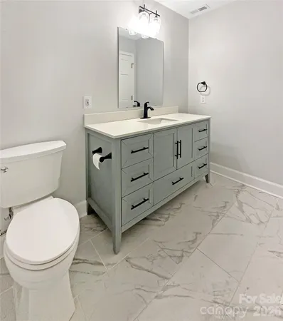 a bathroom with a double vanity sink mirror and toilet