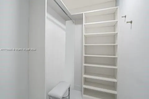 a view of walk in closet with empty racks