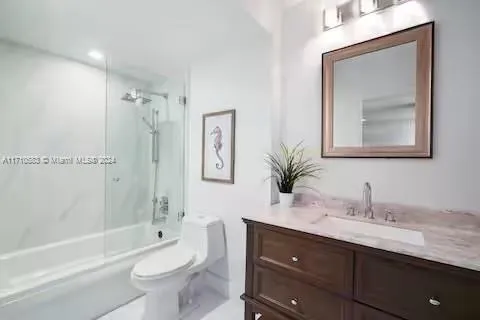 a bathroom with a granite countertop toilet a sink a mirror a bathtub and shower
