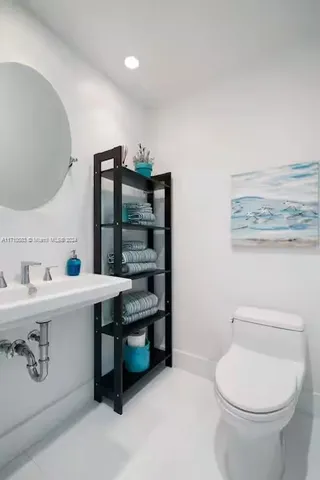 a bathroom with a toilet a sink and mirror