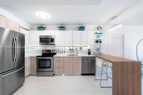 100 Lincoln Road, Unit 739 Miami Beach, FL 33139 - Photo 6 of 33 a kitchen with white cabinets stainless steel appliances and a refrigerator
