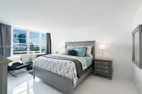 a bedroom with a bed and a large window