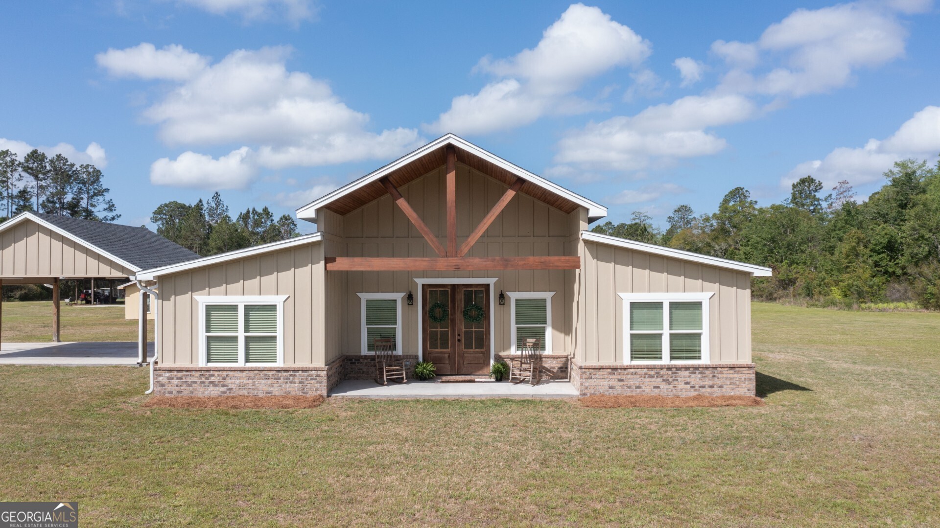 a front view of a house with a garden and yard
