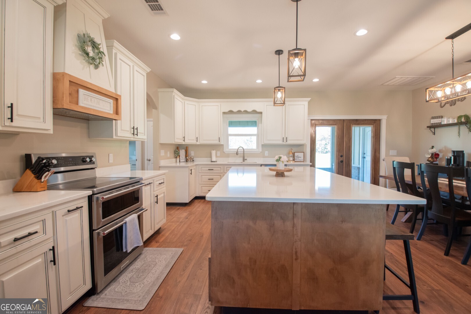 6213 Spanish Creek Road Folkston, GA 31537 - Photo 19 of 38 a kitchen with stainless steel appliances granite countertop a sink a stove and a wooden floors
