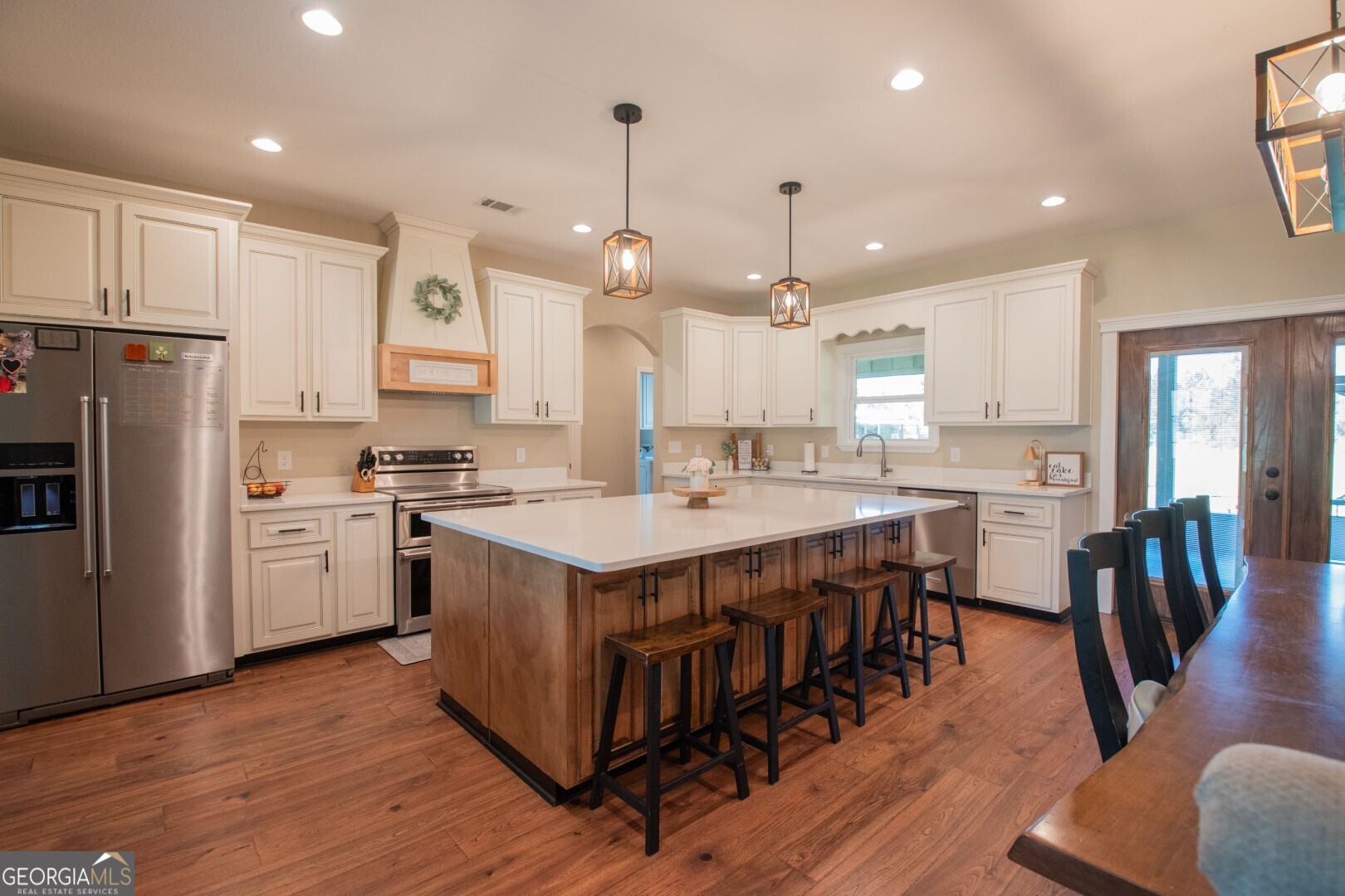 6213 Spanish Creek Road Folkston, GA 31537 - Photo 20 of 38 a open kitchen with stainless steel appliances granite countertop a stove a sink a refrigerator and a dining table with wooden floor