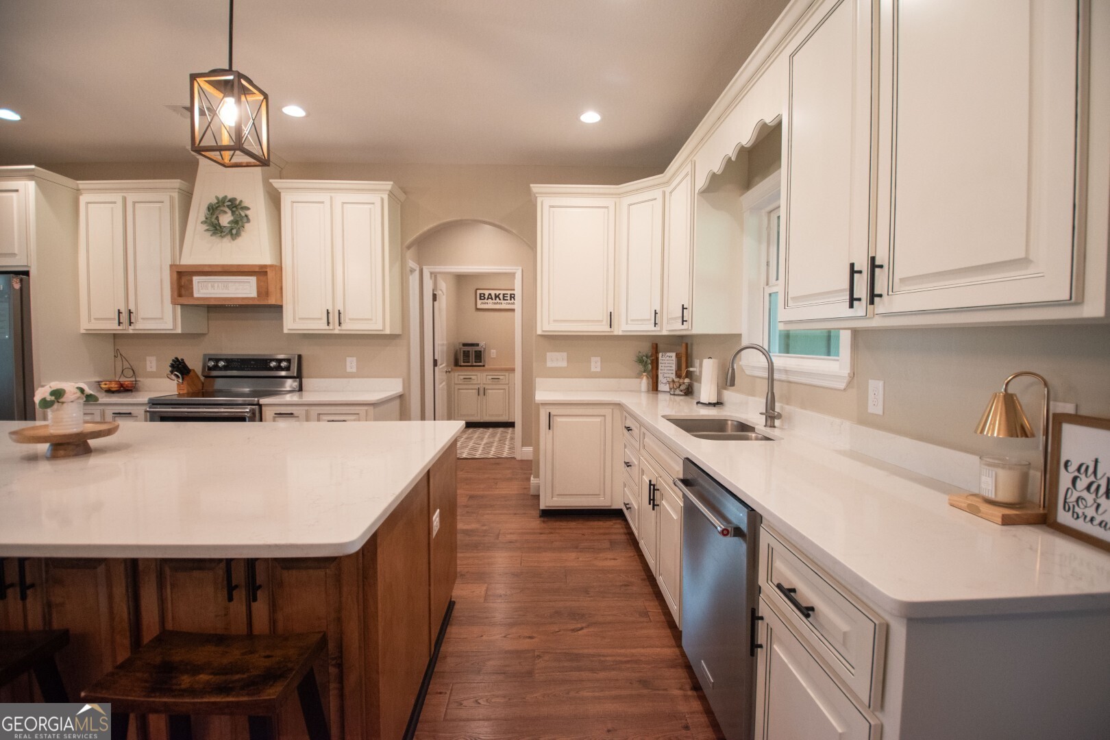 6213 Spanish Creek Road Folkston, GA 31537 - Photo 21 of 38 a kitchen with kitchen island granite countertop a sink a counter space appliances and cabinets