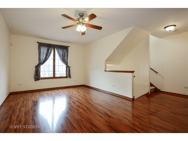 15646 Scotsglen Road Orland Park, IL 60462 - Photo 2 of 14 an empty room with wooden floor chandelier fan and windows