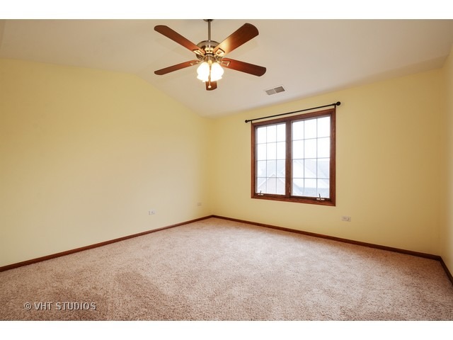 15646 Scotsglen Road Orland Park, IL 60462 - Photo 7 of 14 an empty room with windows and fan