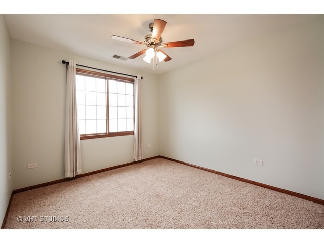 15646 Scotsglen Road Orland Park, IL 60462 - Photo 9 of 14 an empty room with windows and fan