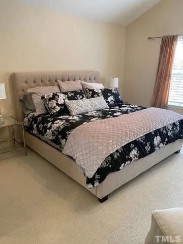 a bed sitting in a bedroom next to a window