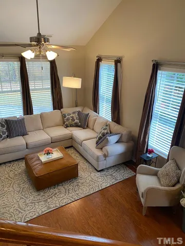 a living room with furniture and a wooden floor