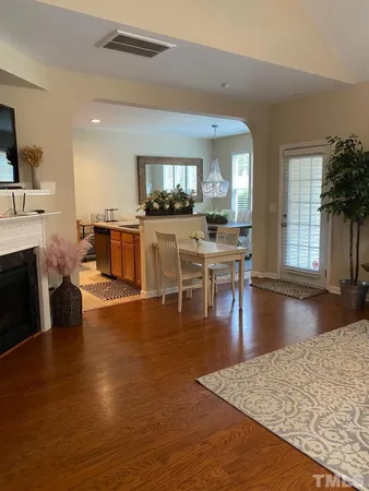 a living room with fireplace a flat screen tv and a dining table