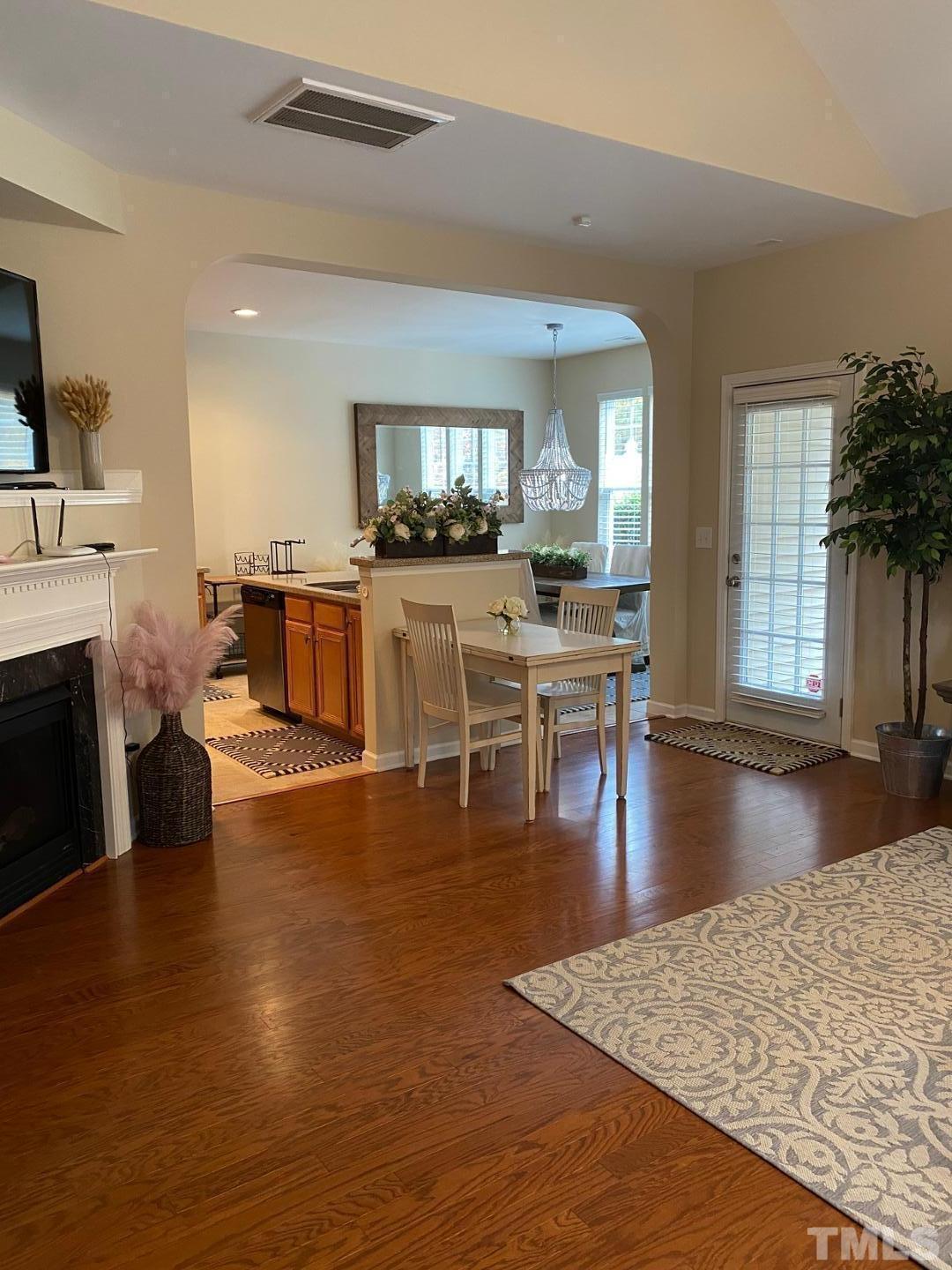 6006 McDevon Drive Raleigh, NC 27617 - Photo 4 of 12 a living room with fireplace a flat screen tv and a dining table