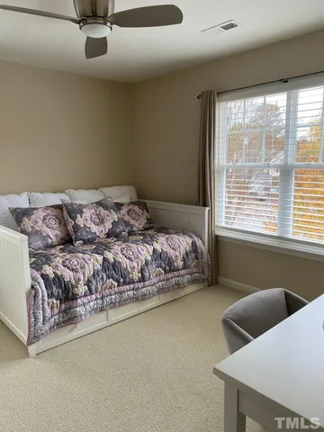 a bed sitting in a bedroom next to a window