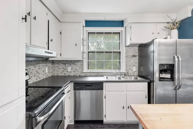 a kitchen with stainless steel appliances granite countertop a sink stove and refrigerator