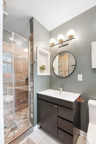 a bathroom with a sink a mirror a vanity and a shower