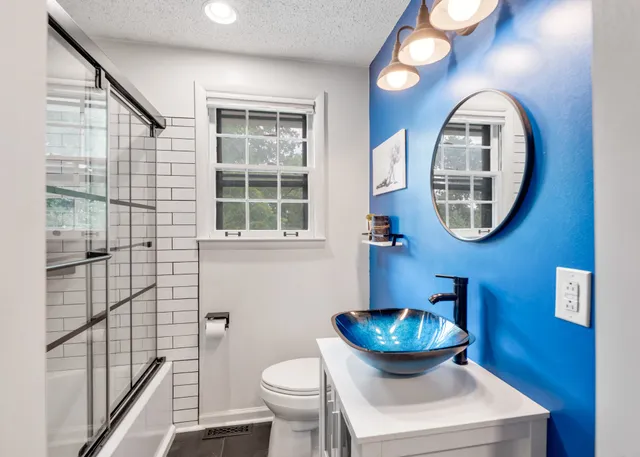 a bathroom with a toilet a sink and mirror