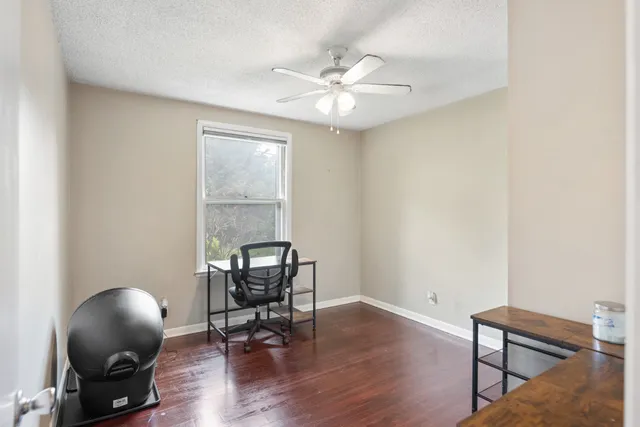 a view of a workspace with wooden floor and a window