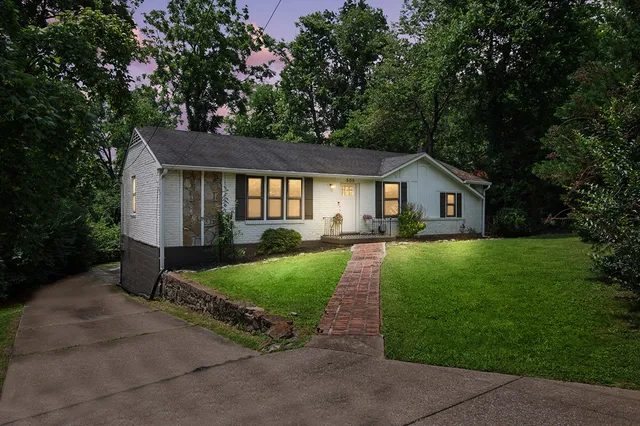 a front view of a house with yard and green space