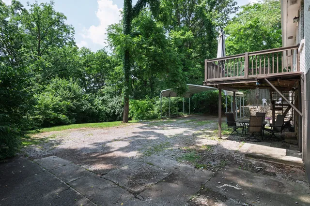 a view of a white house with large windows and a small yard