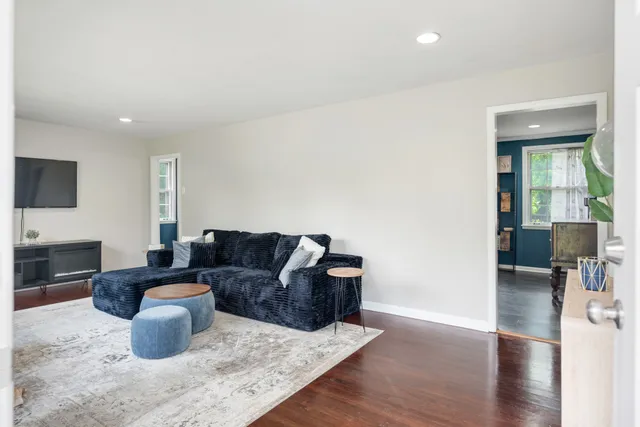 a living room with furniture and a wooden floor