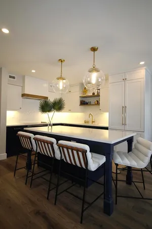 a kitchen with a dining table chairs and wooden floor
