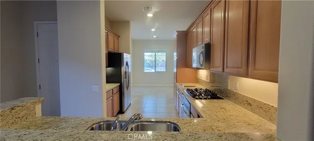 a kitchen with stainless steel appliances granite countertop a stove a microwave and a sink