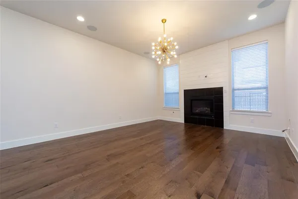an empty room with wooden floor and fireplace