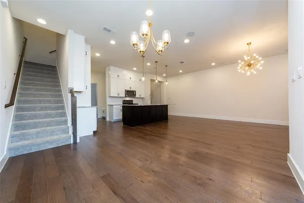 a view of a room with wooden floor and kitchen