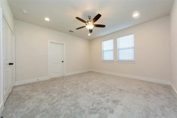 an empty room with window and ceiling fan