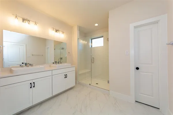 a spacious bathroom with a double vanity sink and a mirror