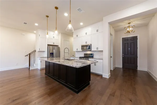 a kitchen with a sink cabinets and wooden floor