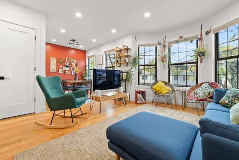 a kitchen with stainless steel appliances kitchen island a table chairs in it and wooden floors