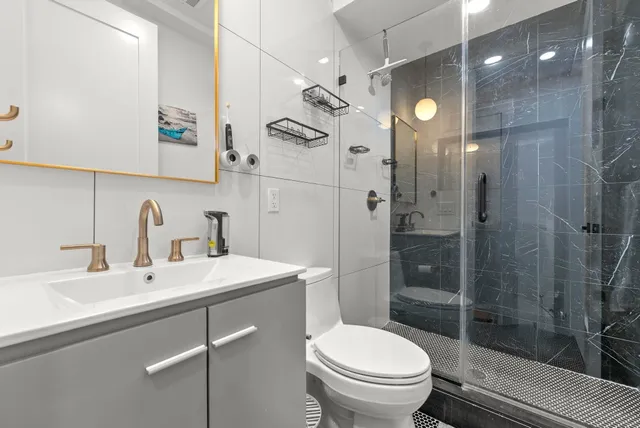 a bathroom with a sink a toilet and shower