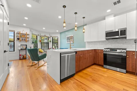 a kitchen with stainless steel appliances kitchen island granite countertop a stove top oven a sink a counter space and cabinets